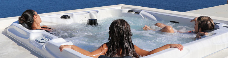 3 Frauen entspannen outdoor am Meer in einem Marken-Whirlpool